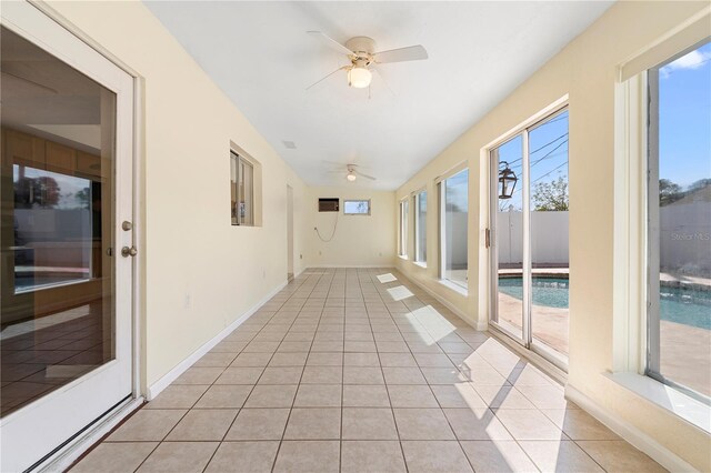 unfurnished sunroom featuring tile patterned floors and baseboards