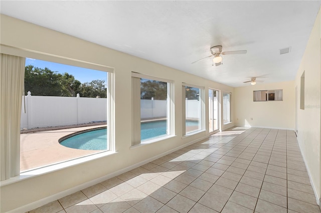 unfurnished room with a ceiling fan, baseboards, light tile patterned flooring, and visible vents