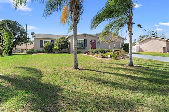 ranch-style home with a garage, driveway, a front lawn, and stucco siding