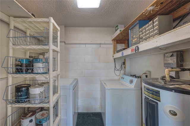 clothes washing area featuring concrete block wall, washer / clothes dryer, electric water heater, and a textured ceiling