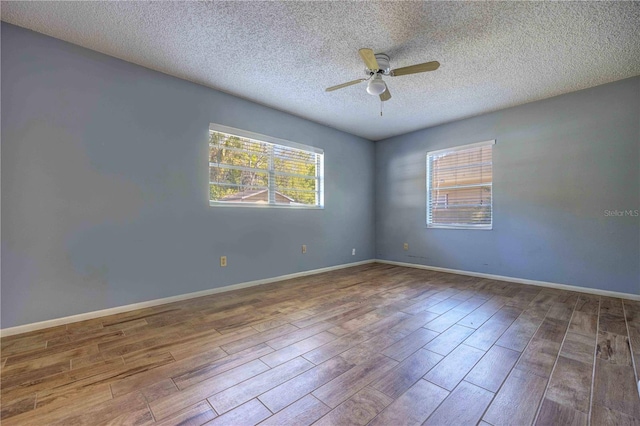 741 Greenway Pl, Daytona Beach, FL 32114 - empty room with plenty of natural light, ceiling fan, wood finished floors, and a textured ceiling