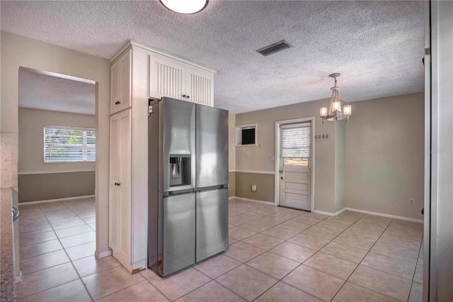 741 Greenway Pl, Daytona Beach, FL 32114 - kitchen featuring stainless steel fridge with ice dispenser, a chandelier, a textured ceiling, light tile patterned floors, and white cabinetry