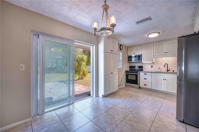 741 Greenway Pl, Daytona Beach, FL 32114 - kitchen with stainless steel appliances, a sink, a chandelier, baseboards, and white cabinetry