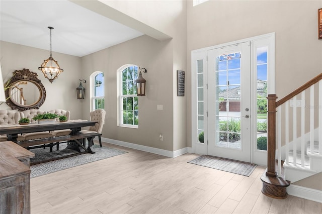 32924 Estate Garden Dr, Wesley Chapel, FL 33545 - entryway with an inviting chandelier, light wood-style flooring, stairs, and baseboards
