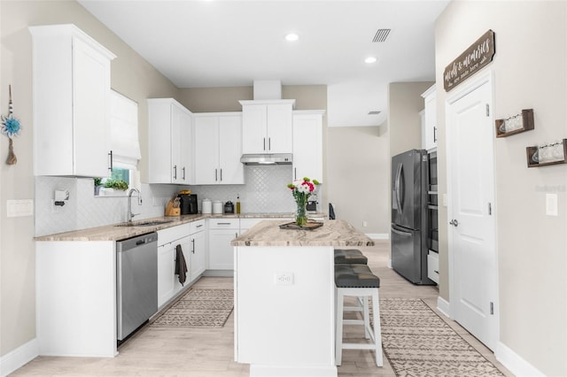 32924 Estate Garden Dr, Wesley Chapel, FL 33545 - kitchen featuring a center island, stainless steel appliances, visible vents, white cabinetry, and a sink