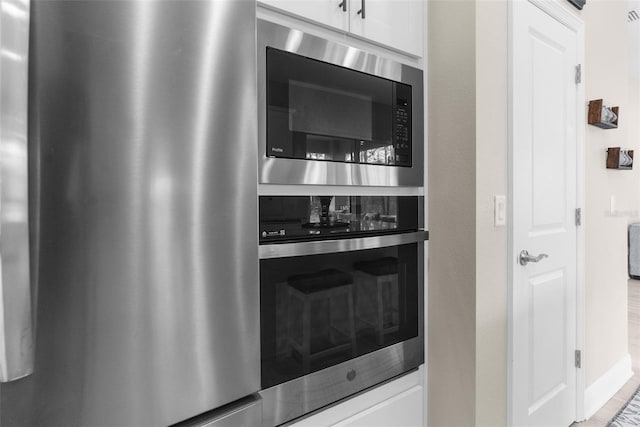 32924 Estate Garden Dr, Wesley Chapel, FL 33545 - kitchen with stainless steel appliances and white cabinetry