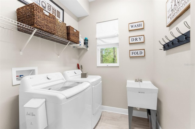 32924 Estate Garden Dr, Wesley Chapel, FL 33545 - clothes washing area with laundry area, washing machine and dryer, light wood-style flooring, and baseboards