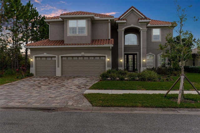 32924 Estate Garden Dr, Wesley Chapel, FL 33545 - mediterranean / spanish home with an attached garage, stucco siding, decorative driveway, and a tiled roof