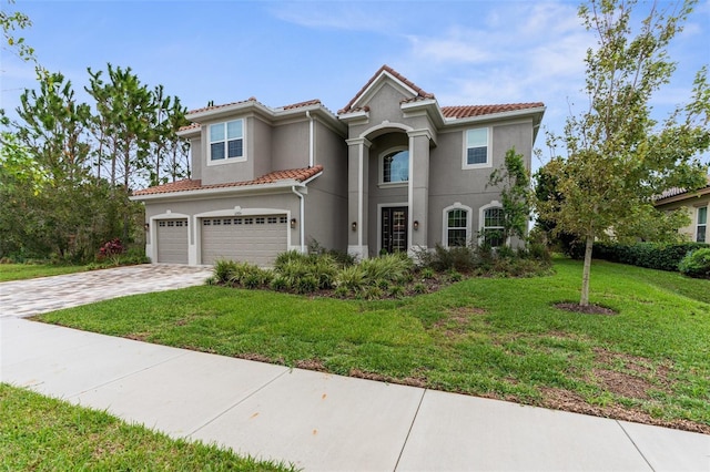 32924 Estate Garden Dr, Wesley Chapel, FL 33545 - mediterranean / spanish-style house featuring a front yard, decorative driveway, a tile roof, and stucco siding