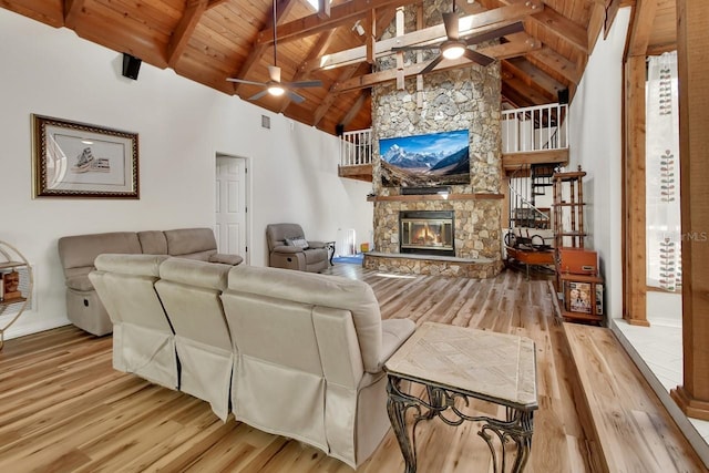 living room with a ceiling fan, light wood-style floors, wooden ceiling, and a fireplace