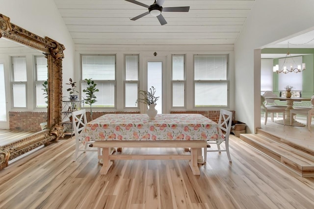 sunroom featuring vaulted ceiling, a wealth of natural light, and ceiling fan with notable chandelier