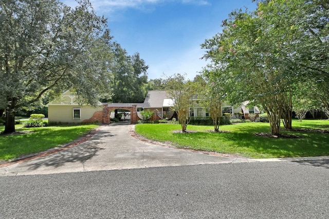 ranch-style home featuring aphalt driveway and a front yard