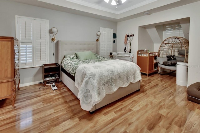 bedroom with baseboards, ornamental molding, and light wood finished floors