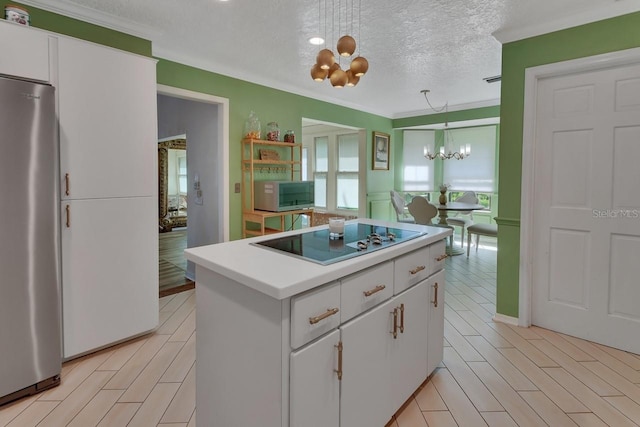 kitchen featuring an inviting chandelier, a kitchen island, light countertops, white cabinets, and stainless steel appliances