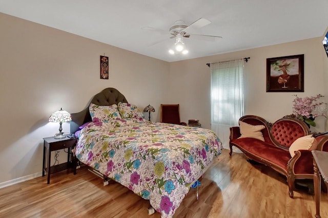 bedroom with baseboards, a ceiling fan, and light wood-style flooring