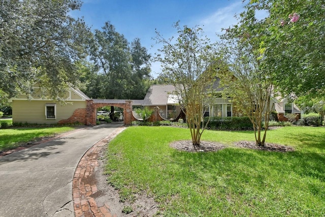 view of front of home with brick siding, driveway, and a front yard