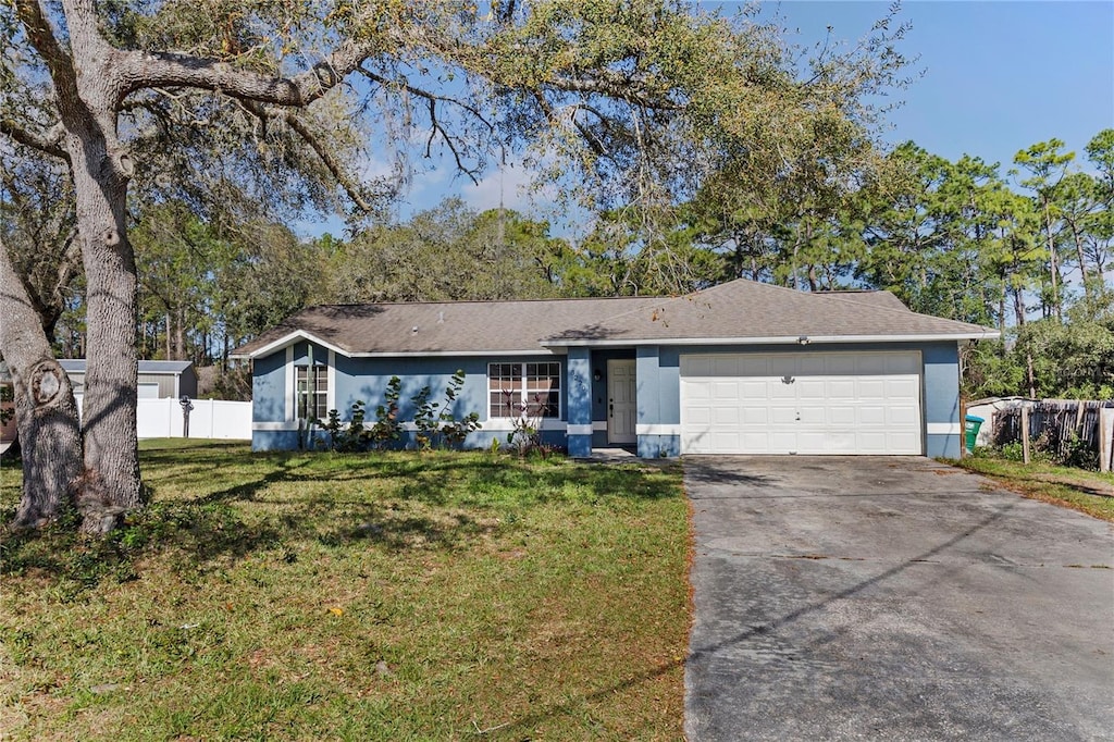 ranch-style house with a garage, fence, driveway, and a front lawn