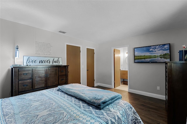 bedroom featuring baseboards, visible vents, wood finished floors, and ensuite bathroom