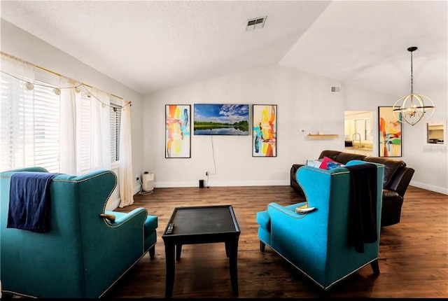 living room featuring lofted ceiling, visible vents, a chandelier, and wood finished floors