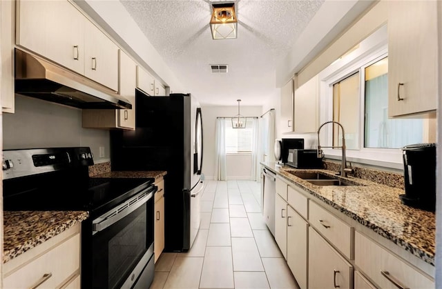 kitchen with a textured ceiling, under cabinet range hood, a sink, stainless steel dishwasher, and electric range oven