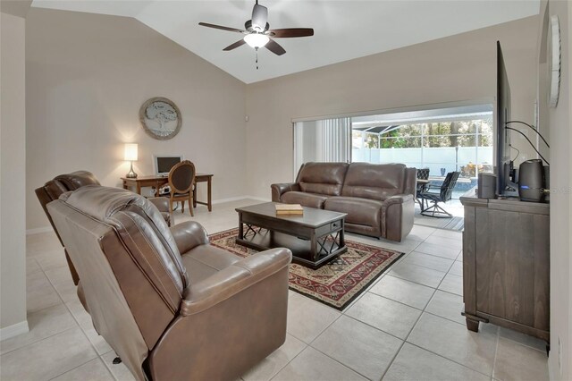 living area with vaulted ceiling, light tile patterned floors, a ceiling fan, and baseboards