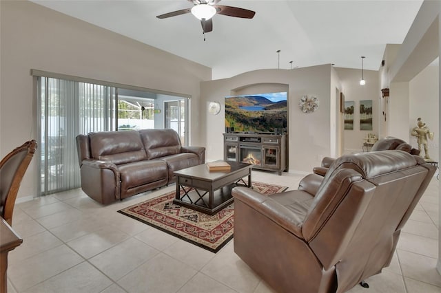 living room with lofted ceiling, light tile patterned floors, ceiling fan, and a glass covered fireplace