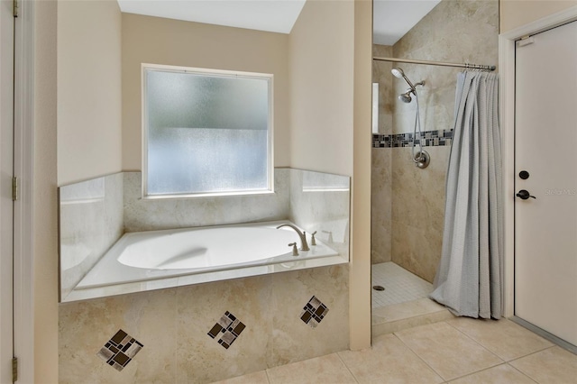 bathroom featuring a garden tub, tiled shower, and tile patterned floors