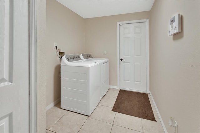 washroom with laundry area, light tile patterned floors, baseboards, and washer and dryer