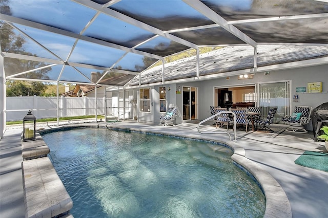 view of swimming pool with a fenced in pool, glass enclosure, a patio, and fence