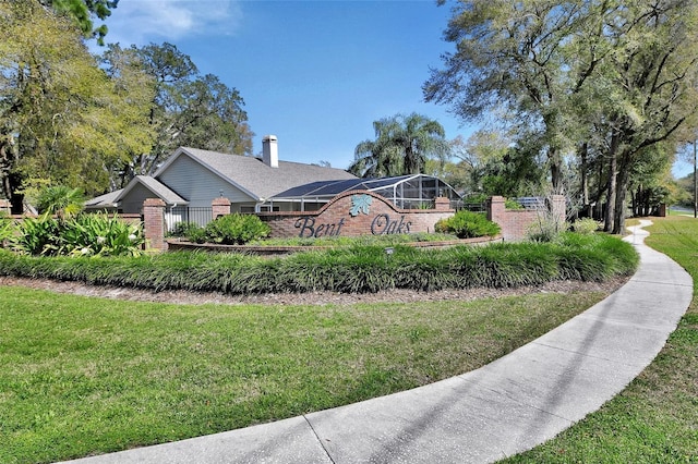 view of property exterior with brick siding, a lawn, and fence