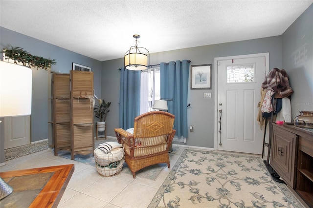 living area with a healthy amount of sunlight, light tile patterned floors, and a textured ceiling