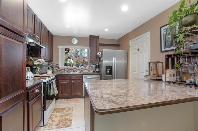 kitchen with under cabinet range hood, a kitchen island, backsplash, white range with electric stovetop, and stainless steel fridge