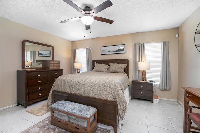 bedroom with a ceiling fan, a textured ceiling, baseboards, and light tile patterned floors