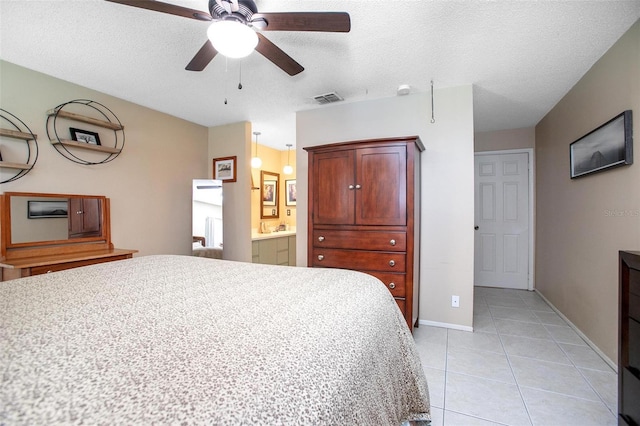 bedroom with light tile patterned floors, baseboards, visible vents, and a textured ceiling