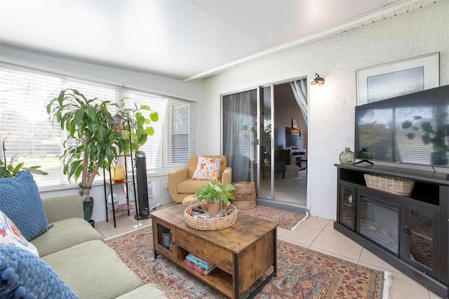 living area with light tile patterned floors, a textured wall, and a wealth of natural light