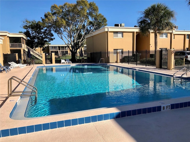 community pool with fence and a patio