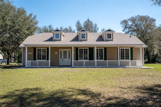 view of front of property with a shingled roof, covered porch, and a front lawn