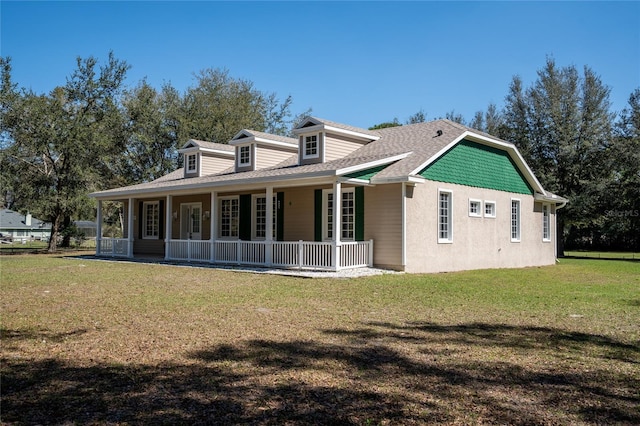 rear view of house featuring a shingled roof, a porch, and a yard