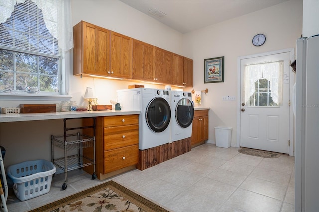 laundry area featuring washer and dryer, cabinet space, visible vents, and light tile patterned floors