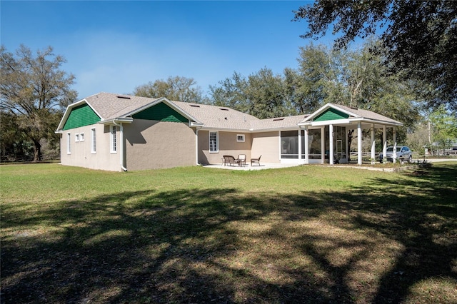 back of house with a sunroom, a lawn, and a patio