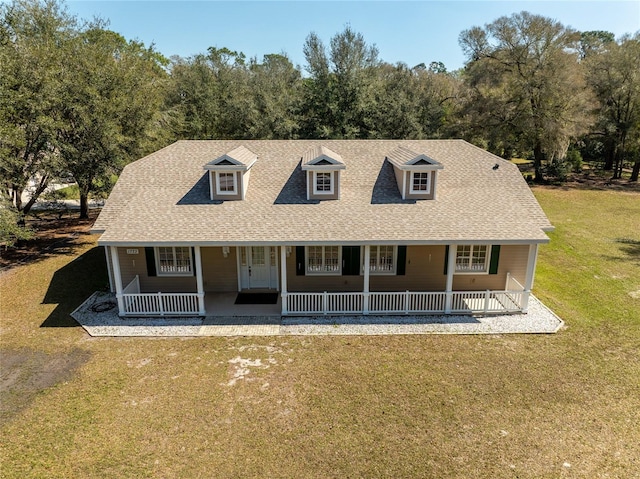 view of front of property featuring a porch, a front yard, and roof with shingles