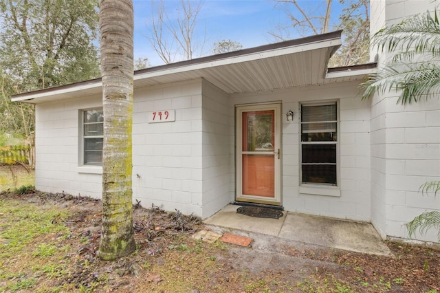 entrance to property featuring concrete block siding