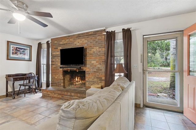 living room featuring a textured ceiling, light tile patterned floors, a brick fireplace, and a ceiling fan