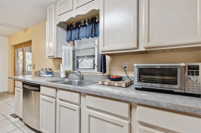 kitchen featuring light tile patterned flooring, a toaster, a sink, light countertops, and dishwasher