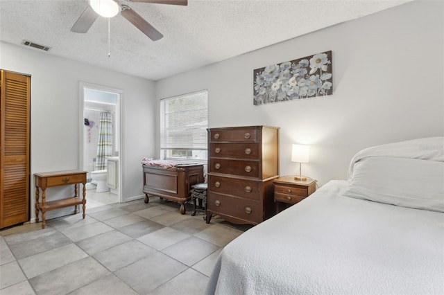 bedroom featuring a textured ceiling, ensuite bathroom, a ceiling fan, visible vents, and a closet