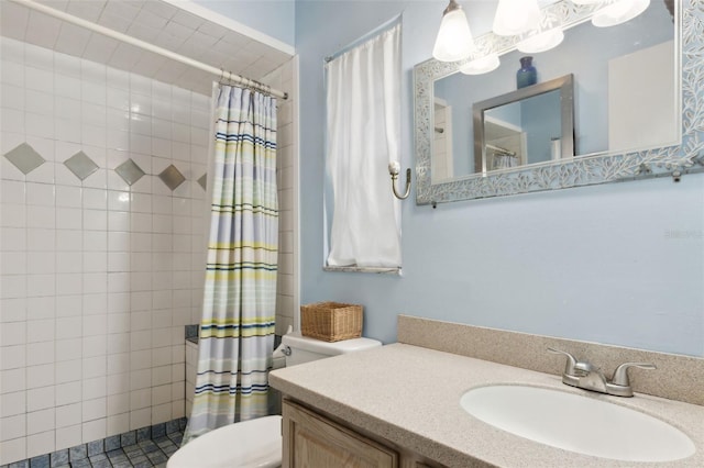 bathroom featuring toilet, tiled shower, and vanity