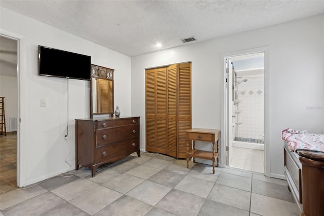 bedroom with a textured ceiling, visible vents, and baseboards