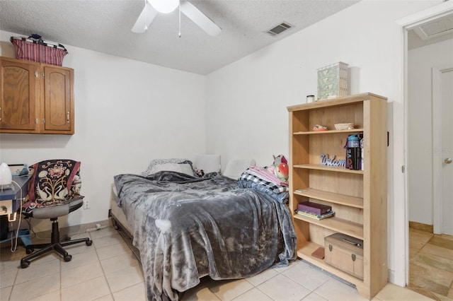 bedroom featuring a ceiling fan, visible vents, a textured ceiling, and light tile patterned flooring