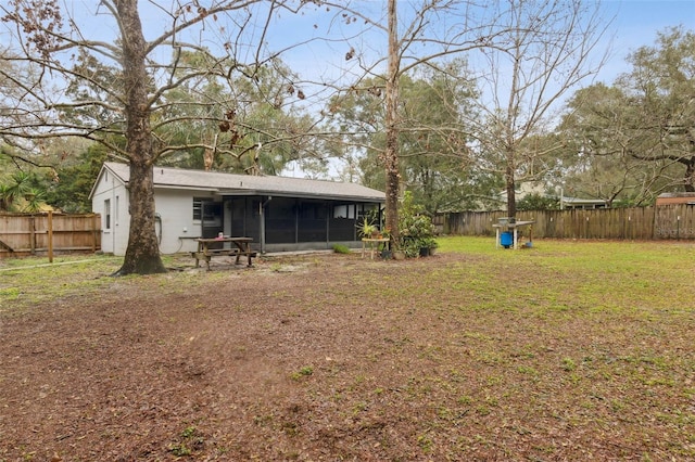 view of yard with a sunroom and a fenced backyard