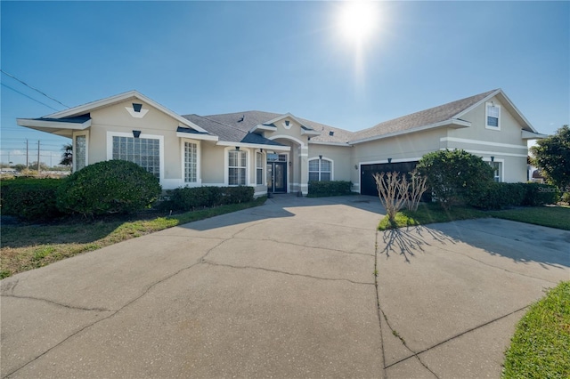 view of front of house featuring an attached garage, concrete driveway, and stucco siding